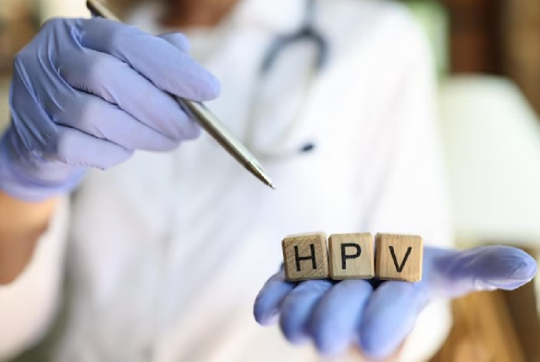 Imagem de uma pessoa de jaleco branco segurando três dados que formam a palavra HPV.