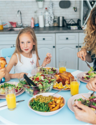 Foto de uma família reunida na mesa para comer.