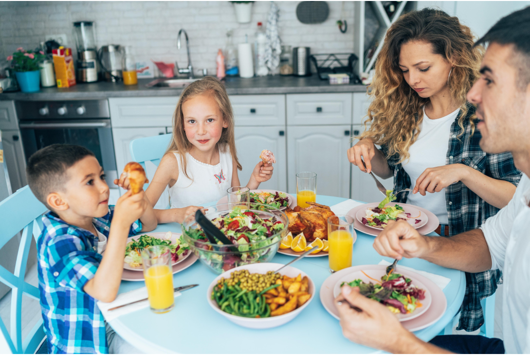 Foto de uma família reunida na mesa para comer.