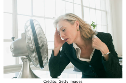 Foto de uma mulher passando calor no trabalho.