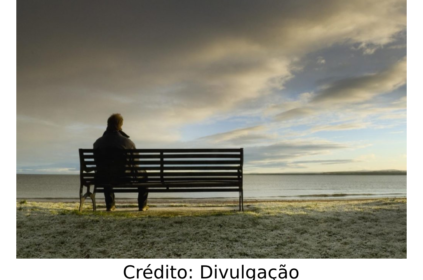 Pessoa solitária sentada num banco.