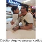 Homem com Implante coclear com seu filho na paraça de alimentação de um shopping.