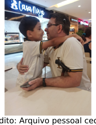 Homem com Implante coclear com seu filho na paraça de alimentação de um shopping.