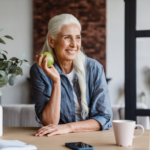 Imagem ilustrativa de uma mulher idossa com uma fruta nas mãos.