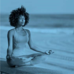 Foto ilustrativa de uma mulher negra sentada na praia.