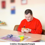Foto ilustrativa de uma pessoa adulta com Síndrome de Down realizando atividades durante terapia ocupacional.
