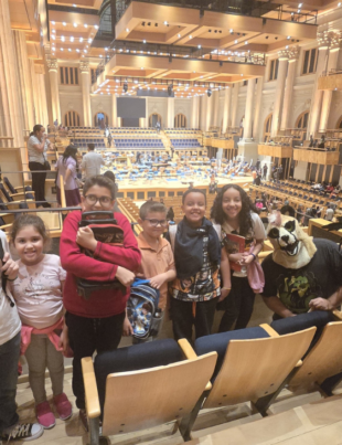 Foto de alunos da Orquestra Lyra Mojimiriana na Sala São Paulo.