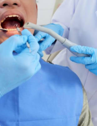 Foto ilustrativa de um dentista cuidando dos dentes de um paciente.