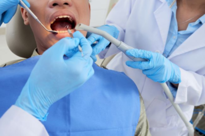Foto ilustrativa de um dentista cuidando dos dentes de um paciente.