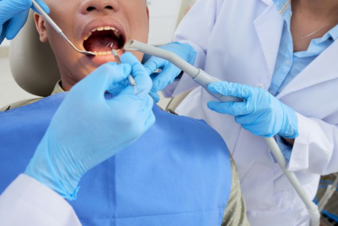 Foto ilustrativa de um dentista cuidando dos dentes de um paciente.