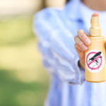 Foto ilustrativa de uma pessoa segurando um frasco de repelente.