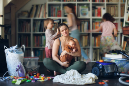 Foto ilustrativa de uma mulher com semblante triste com bêbe no colo.