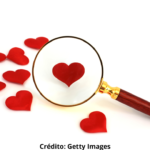 Imagem ilustrativa de uma lupa ampliando um dos papéis vermelhos em forma de coração.