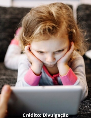 Imagem ilustrativa de uma criança assistindo algo no tablet.