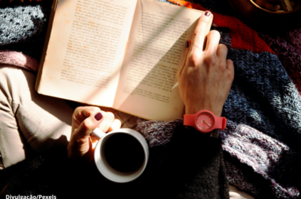 Imagem ilustrativa de uma pessoa tomandoc afé e lendo um livro.