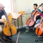 Foto de alunos do Polo Regional de Jundiaí do Projeto Guri tendo aula de violencelo.