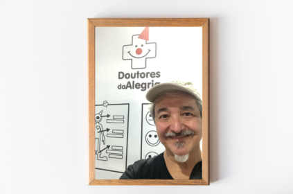 Imagem-montagem com foto do fundador da Doutores da Alegria e entrevistado do dia.