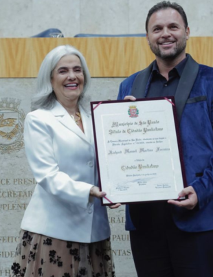 Foto do momento de entrega do Título de Cidadão Paulistano a Richard Manoel.