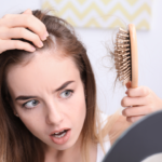 Imagem ilustrativa de uma mulher vendo que está perdendo cabelo.