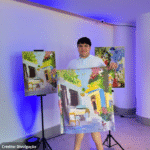 Foto do artista que mostra orgulhoso alguns de seus quadros que viraram estampas de lenços.