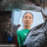 Foto ilustrativa de uma mulher reciclando uma garrafa PET.