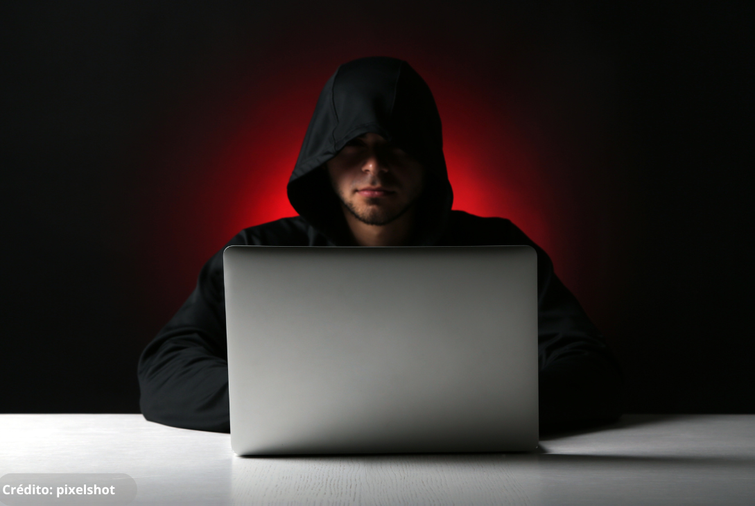 Foto ilustrativa de um criminoso usando o computador para dar golpes.