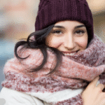 Foto ilustrativa de uma mulher usando roupas de frio na rua.