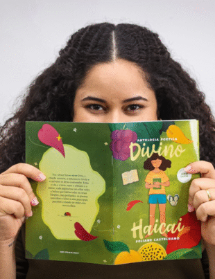 Foto da escritora Poliane Castelhano com seu livro de poemas.