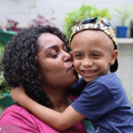 Foto de uma mulher negra com uma criança que pode ser uma das assistidas por um dos projetos apoiados pelo Instituto Ronald McDonald.