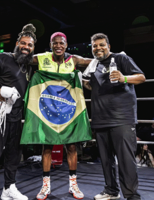 Foto do atleta com a bandeira do Brasil.