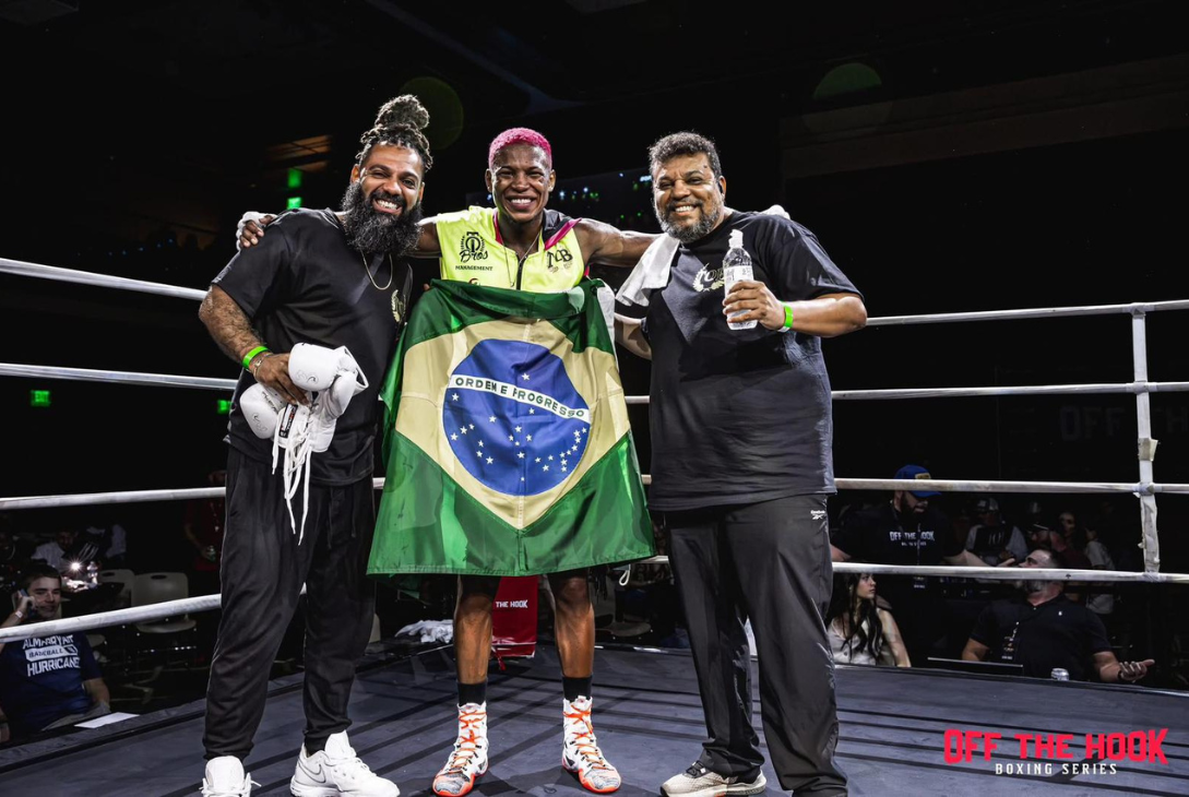 Foto do atleta com a bandeira do Brasil.