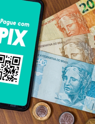 Imagem ilustrativa de uma mesa com dinheiro em notas e moedas e um celular com Pix na tela.
