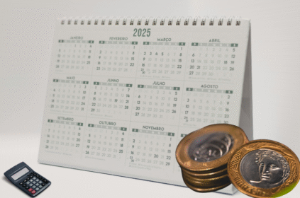 Imagem ilustrativa de um calendário com moedas e uma calculadora do lado.