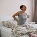 Imagem ilustrativa de uma pessoa acordando com dor na costa.