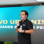 Foto de Eduardo Oliveira, sócio-diretor da CINQ Inteligência Urbana palestrando em seminário promovido pela FIEG.